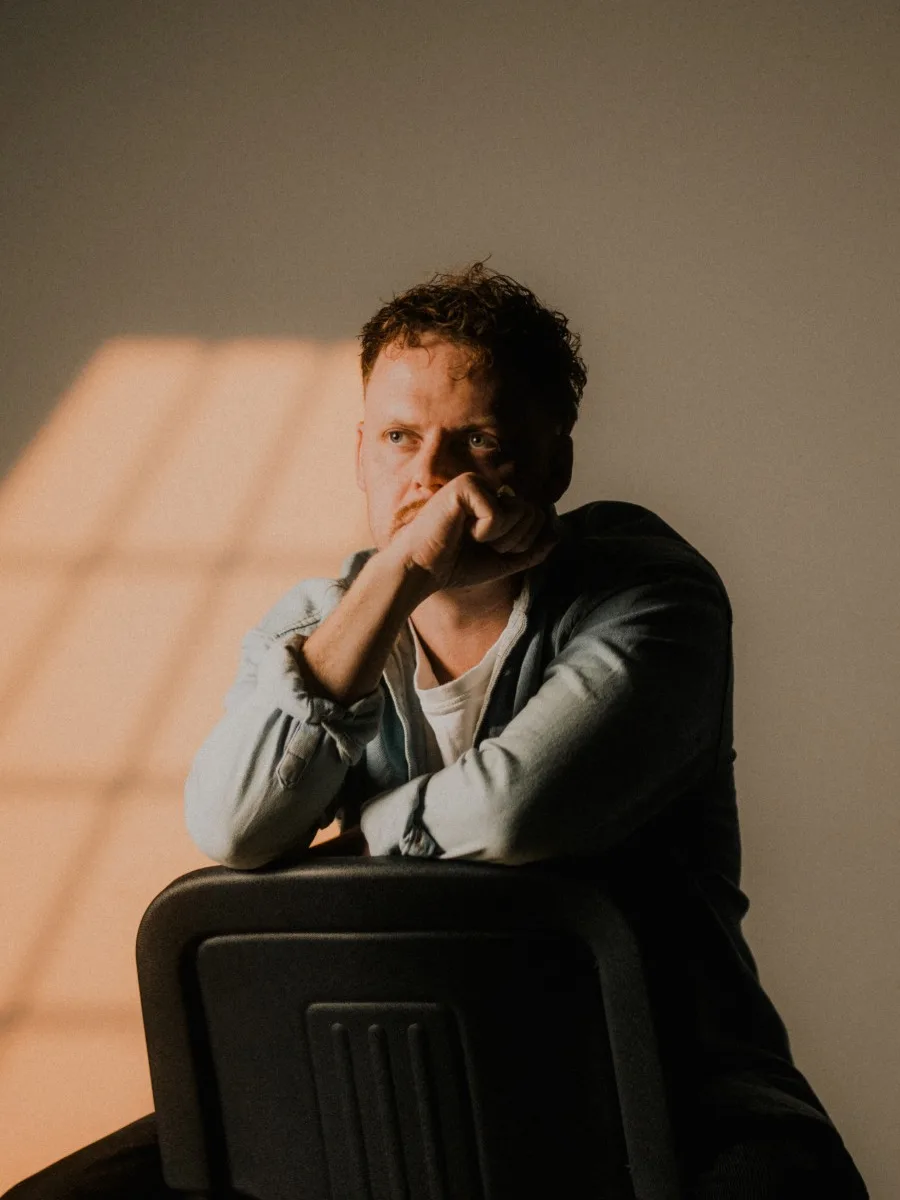 Reuben Mowle, sitting in a patch of window light